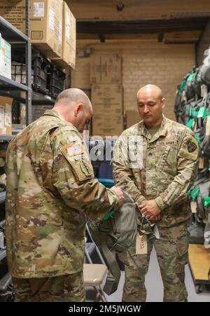 STATI UNITI 5 Jeffrey Swem, coordinatore del programma per il Department of the Army Award for Maintenance Excellence, ispeziona con il personale una maschera per uso generale del servizio congiunto insieme ad altre apparecchiature di risposta nucleari, biologiche e chimiche. Damian Acevedo, assegnato alla 145th Maintenance Company, durante la valutazione dell’unità presso la Staten Island Armory di New York City, 20 marzo 2022. Il programma di premiazione riconosce annualmente le unità dell'esercito che hanno dimostrato eccellenza in una serie di operazioni di manutenzione. Foto Stock