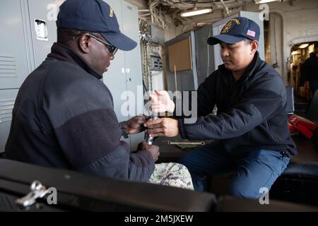 220321-N-VJ326-1005 SAN DIEGO (21 marzo 2022) – Aviation Boatswain’s Mate Airman Sidi Ouedraogo, di Newark, N.J., a sinistra, e Aviation Boatswain’s Mate Airman Mark Agpalasin, di New York, riparano una pistola ad ago a bordo di una nave d’assalto anfibia USS Tripoli (LHA 7), marzo 21. Tripoli è una nave d'assalto anfibio di classe americana ospita a San Diego. Foto Stock