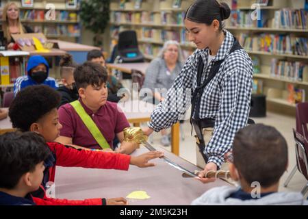 Tampa, Fla. (22 marzo 2022) Airman Megan Kearns mostra una spada ai bambini della scuola per la Tampa Bay Navy Week. USS Constitution, è la nave da guerra commissionata più antica del mondo, e ha giocato un ruolo cruciale nelle guerre barbariche e nella guerra del 1812, difendendo attivamente le vie marittime dal 1797 al 1855. Durante le normali operazioni, i marinai a servizio attivo di stanza a bordo della USS Constitution offrono tour gratuiti e visite pubbliche a più di 600.000 persone all'anno, poiché sostengono la missione della nave di promuovere la storia e il patrimonio marittimo della Marina e di sensibilizzare l'opinione pubblica sull'importanza di un sustai Foto Stock