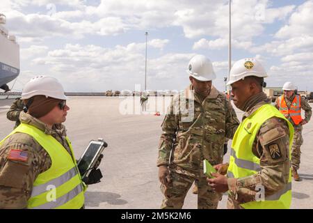 STATI UNITI James Smith (a sinistra), comandante del 21st Theater Sustainment Command, discute la nuova tecnologia di tracciamento delle attrezzature militari con 2nd Lt. Marcus Brown, responsabile dell'operazione portuale di debarazione (SPOD), durante 3rd Armored Brigade Combat Team, 4th Infanty Division's Vehicle and Equipment SPOD Operation, 21 marzo 2022, Alexandroupoli, Grecia. Il 3rd ABCT è la nona unità rotazionale blindata a schierarsi in Europa a sostegno della risolutezza atlantica. La “Brigata di ferro” si unirà ad altre due brigate in Europa sotto il comando degli Stati Uniti Army V Corps, che mantiene il comando contro Foto Stock