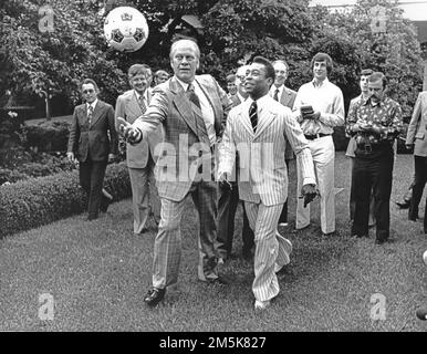 Il presidente degli Stati Uniti Gerald R. Ford e il grande calcio brasiliano Pele rimbalzano una palla di calcio intorno al Rose Garden della Casa Bianca a Washington, DC il 28 giugno 1975. Pele è il giocatore di calcio più pagato al mondo.Credit: Benjamin E. 'gene' Forte/CNP /MediaPunch Foto Stock