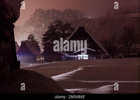 Tradizionale Casa A-frame in rosa bagliore nebbiosa come la neve cade in montagna Foto Stock