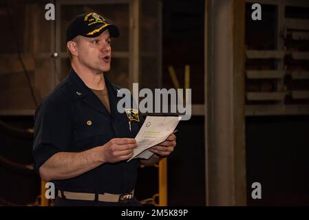 220321-N-XB010-1006 SASEBO, Giappone (21 marzo 2022) il capitano Douglas Graber, comandante della USS New Orleans (LPD 18), si rivolge ai marinai nel ponte dei pozzi della nave durante una chiamata a tutte le mani. New Orleans, parte dell'America Amphibious Ready Group, insieme alla Marine Expeditionary Unit 31st, opera nell'area di responsabilità della flotta 7th degli Stati Uniti per migliorare l'interoperabilità con alleati e partner e fungere da pronta forza di risposta per difendere la pace e la stabilità nella regione dell'Indo-Pacifico. Foto Stock