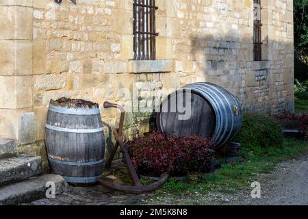 Due botti di legno e un'ancora esterna davanti ad un muro di pietra e alcuni gradini Foto Stock