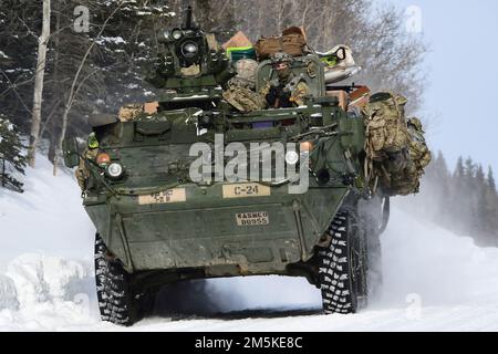 Un veicolo Stryker del Battaglione 3rd, 21st Fanteria Regiment si muove lungo una strada nevosa nella Donnelly Training Area durante il Joint Pacific multinazionale Readiness Center 22-02, 22 marzo 2022. Questo esercizio è stato progettato per convalidare la squadra di combattimento di Stryker Brigade 1st dell'esercito degli Stati Uniti in Alaska, la formazione, la preparazione e le capacità di 25th Infantry Division per il freddo. (Foto esercito/John Pennell) Foto Stock