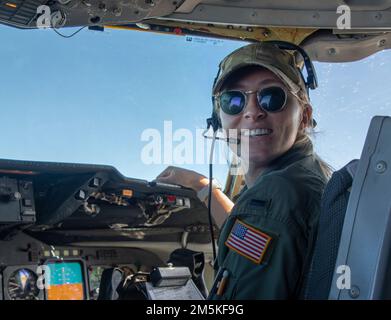 STATI UNITI Air Force 1st Lt. Macy Miller, 6th Air Refuging Squadron KC-10 Extender pilota, comunica con l'equipaggio durante il volo del mese della storia delle donne presso la base dell'aeronautica militare Travis, California, 22 marzo 2022. In onore del mese della storia delle donne, un equipaggio di volo femminile KC-10 delle Air Mobility Wings 60th e 349th ha volato su una missione di addestramento per il rifornimento aereo in California e Oregon. Foto Stock