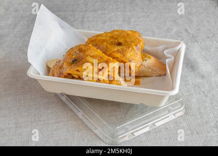 Un paio di succulenti spiedini di tortilla con pane in un contenitore per la consegna a domicilio Foto Stock