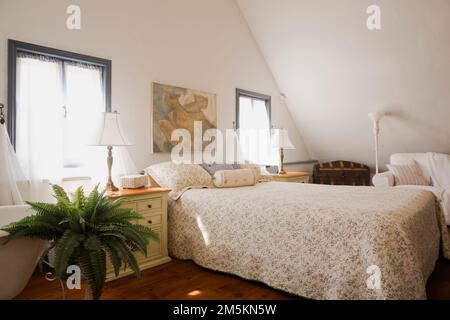 Letto matrimoniale con copriletto fiorito nella camera da letto principale al piano superiore, all'interno di una casa in legno ricostruita degli anni '1840. Foto Stock
