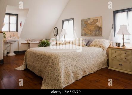 Letto matrimoniale con copriletto fiorito nella camera da letto principale al piano superiore, all'interno di una casa in legno ricostruita degli anni '1840. Foto Stock
