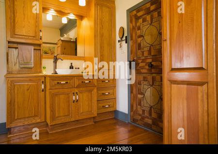 Lavandino in legno con ciotola, lavandino e specchio nel bagno principale all'interno ricostruito casa in legno degli anni '1840. Foto Stock