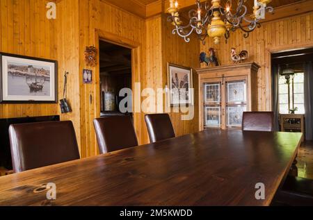 Lungo tavolo da pranzo e sedie in sala da pranzo all'interno della vecchia casa in stile cottage 1920s. Foto Stock