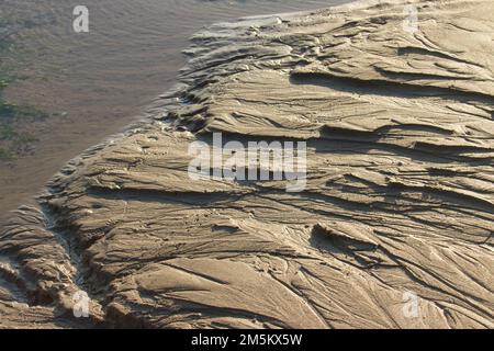 Motivo di texture di fondo di sabbia bagnata. Foto Stock