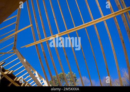 Utilizzando un telaio esistente travi a vista telaio tetto in legno per sostenere il tetto di nuova costruzione casa avambraccio Foto Stock