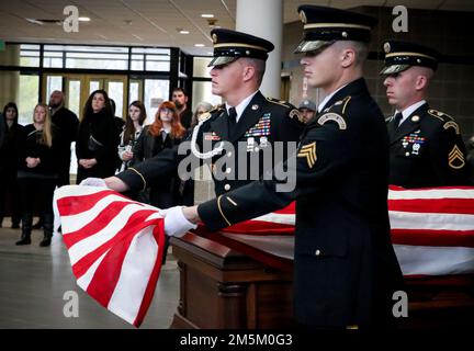 I soldati della Guardia Nazionale dell'Iowa iniziano a piegare una bandiera americana durante una dimostrazione commemorativa della Guardia d'onore presso il quartier generale della Joint Force a Johnston, Iowa, il 3 maggio 2022. I membri della Guardia d'onore hanno collaborato con il Des Moines Area Community College di Ankeny per educare gli studenti agli affari mortuari. Foto Stock