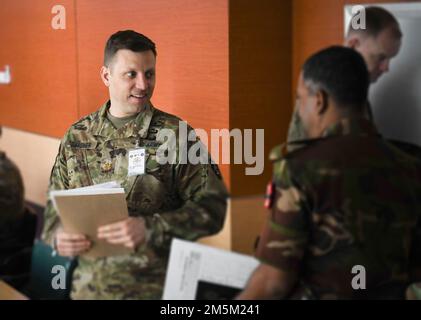 STATI UNITI James Gardner, delegato della Guardia Nazionale dell'Oregon e ufficiale dell'Avvocato Generale del Giudice (JAG) (a sinistra), parla con un membro del servizio del Bangladesh durante una pausa da un esercizio di scenario di formazione presso il centro di formazione dell'operazione di sostegno alla pace del Bangladesh Institute of Peace Support (BIPSOT) a Dhaka, Bangladesh 24 marzo 2022. I delegati della Guardia Nazionale dell'Oregon partecipano all'esercitazione Tiger Lightning 2022, un'esercitazione bilaterale sponsorizzata dagli Stati Uniti Comando Indo-Pacific e ospitato dalle forze armate del Bangladesh, rafforzando la disponibilità alla difesa del Bangladesh, costruendo l'interoperabilità operativa, Foto Stock