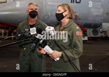 Amy Bauernschmidt, a destra, comandante della portaerei di classe Nimitz USS Abraham Lincoln (CVN 72), risponde alle domande di intervista dei media filippini nella baia di Hangar a bordo di Abraham Lincoln. 2022 24 Abraham Lincoln Strike Group è in fase di implementazione pianificata nell'area delle operazioni della flotta 7th degli Stati Uniti per migliorare l'interoperabilità attraverso alleanze e partnership e al tempo stesso fungere da forza di risposta pronta a sostegno di una regione indomPacifico libera e aperta. Foto Stock