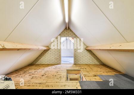 l'interno di un edificio con pavimenti in legno e pareti a vista in uno spazio incompiuto che viene utilizzato per la costruzione Foto Stock