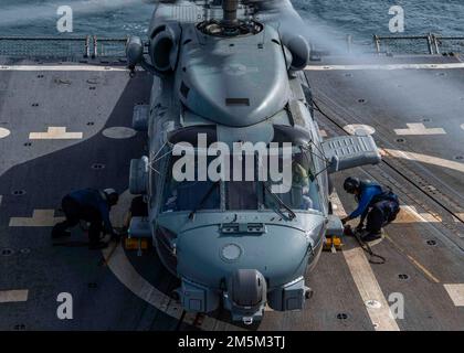 GOLFO ARABICO (24 marzo 2022) Seaman Cameron Collins, a sinistra, E Seaman Bobby Cunningham, a destra, rimuovono i cunei e le catene da un elicottero MH-60R Sea Hawk, attaccato ai “Raptors” di Helicopter Maritime Strike Squadron (HSM) 71 durante le operazioni di volo a bordo del cacciatorpediniere missilistico guidato USS Gridley (DDG 101) nel Golfo Arabico, marzo 24. Gridley è schierato nella flotta degli Stati Uniti 5th area di operazioni a sostegno di operazioni navali per garantire la stabilità e la sicurezza marittima nella regione centrale, collegando il Mediterraneo e Pacifico attraverso l'Oceano Indiano occidentale e tre choke strategico Foto Stock