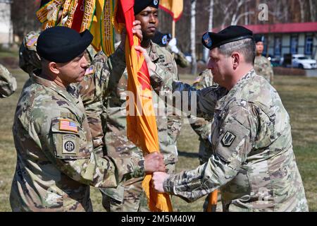 Il Comandante USA della Brigata artiglieria 41st Daniel Miller, a destra, consegna i colori dell'unità agli Stati Uniti Il comando dell'esercito Sgt. Maj. Kristian Castro, il comandante entrante della brigata maggiore, durante una cerimonia di assunzione di responsabilità presso la Torre Barracks Grafenwoehr Parade Field, Germania, 24 marzo 2022. Foto Stock