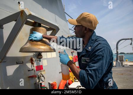 OKINAWA, Giappone (24 marzo 2022) Specialista culinario 2nd Classe Tyrie Mardochai, di Savannah, Georgia, brilla la campana della nave a bordo del cacciatorpediniere missilistico guidato Arleigh Burke-class USS Ralph Johnson (DDG 114). Ralph Johnson è assegnato alla Task Force 71/Destroyer Squadron (DESRON) 15, la più grande DESRON della Marina e la principale forza di superficie della flotta statunitense 7th. Foto Stock