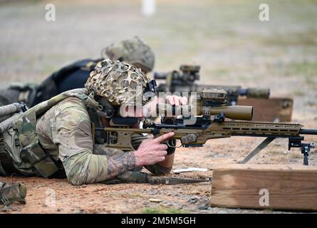 Un concorrente della United States Army Special Operations Command (USASOC) International Snipper Competition, regola l'ingrandimento su un fucile scope mentre si impegna a lungo distanza obiettivi a Fort Bragg, North Carolina, 24 marzo 2022. Ventuno squadre hanno partecipato alla USASOC International Sniper Competition del 13th, dove gli istruttori del United States Army John F. Kennedy Special Warfare Center and School hanno progettato una serie di eventi che hanno sfidato la capacità del team di due persone di lavorare insieme con velocità e precisione, coinvolgendo al tempo stesso obiettivi di Multiple distanze in vari tipi o Foto Stock