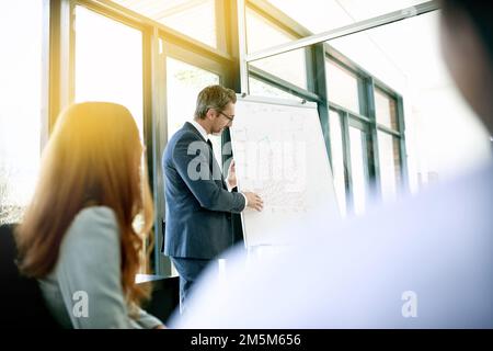 Far scorrere i dati al suo team. un uomo d'affari che fa una presentazione ai suoi colleghi in un ufficio. Foto Stock