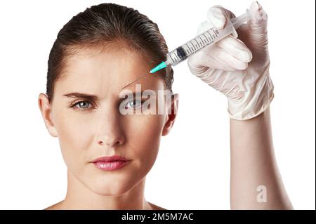 Shes serio circa anti-invecchiamento. Studio shot di una giovane donna attraente ottenere un'iniezione per scopi cosmetici. Foto Stock