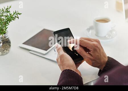 Rimanere ben connessi è importante quando si inizia una nuova attività. un uomo che usa un telefono alla sua scrivania in un ufficio. Foto Stock