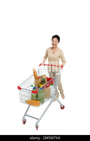 Tenda a donne di mezza età e di età spingere il carrello della spesa Foto Stock