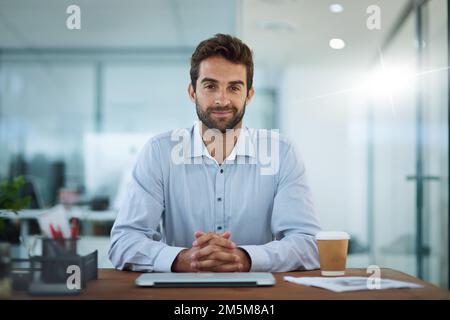 HES lavorando su alcune idee nuove. Ritratto di un giovane uomo d'affari seduto alla scrivania in un ufficio. Foto Stock