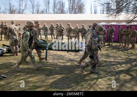 STATI UNITI I soldati dell'esercito assegnati a 2nd reggimento di cavalleria, insieme ai soldati NATO Ally e Partner, trasportano un soldato via su un litro durante un corso di Lifesaver di combattimento alla base aerea di Mihail Kogalniceanu, Romania, il 24 marzo 2022. Il reggimento della cavalleria del 2nd fa parte del V corpo, il corpo americano schierato in avanti in Europa, che lavora insieme agli alleati della NATO e ai partner della sicurezza regionale per fornire forze pronte al combattimento, eseguire esercitazioni di formazione congiunte e multinazionali, E mantiene il comando e il controllo di tutte le unità rotazionali e assegnate nel teatro europeo. Il corso CLS consente di familiarizzare con il personale militare Foto Stock