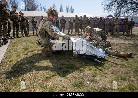 STATI UNITI Soldati dell'esercito assegnati a 2nd reggimento di cavalleria, applicare una coperta termica durante un corso di Lifesaver di combattimento alla base aerea di Mihail Kogalniceanu, Romania il 24 marzo 2022. Il reggimento della cavalleria del 2nd fa parte del V corpo, il corpo americano schierato in avanti in Europa, che lavora insieme agli alleati della NATO e ai partner della sicurezza regionale per fornire forze pronte al combattimento, eseguire esercitazioni di formazione congiunte e multinazionali, E mantiene il comando e il controllo di tutte le unità rotazionali e assegnate nel teatro europeo. Il corso CLS consente al personale militare di acquisire familiarità con le competenze mediche di base necessarie per il trauma c Foto Stock