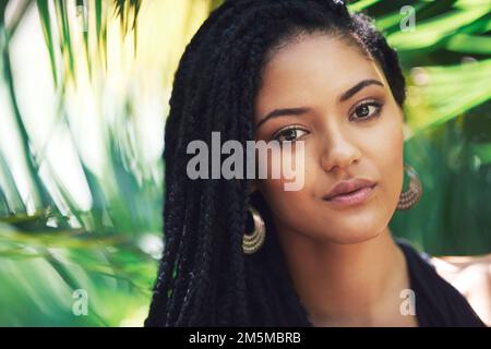 Bellezza botanica. Ritratto di una giovane donna attraente che si posa su uno sfondo frondoso. Foto Stock