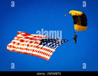 Old Glory si tuffa nel cielo limpido e blu sopra Tampa Bay come membro del Para-Commandos – US Special Operations Command Parachute Team – scende sul campo aereo alla base dell'aeronautica di MacDill, Florida, durante il Tampa Bay Airfest 25 marzo 2022. I Para-Commandos comprendono operatori speciali attivi, come forze speciali dell'esercito, Rangers dell'esercito, Navy Seals, Controller di combattimento dell'aeronautica e Marine Raiders. Il Para-Commandos dispone anche di personale di supporto che si occupa di includere componenti di riserva da ogni filiale del servizio. Squadre come i para-comandanti viaggiano in tutto il mondo per inspi Foto Stock