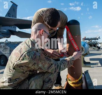 Equipaggio addetto al carico delle armi gli Airmen assegnati allo Squadrone della generazione dei combattenti del 334th si preparano a caricare un'unità bomba a guida inerte su un F-15E Strike Eagle durante una competizione annuale di Load Crew alla base aerea Seymour Johnson, North Carolina, 25 marzo 2022. Gli equipaggi sono stati responsabili di garantire che le munizioni fossero sicure, riparabili e correttamente configurate. Foto Stock