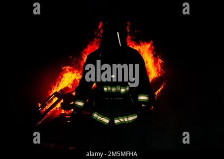 Un vigile del fuoco con installazioni del corpo dei Marine Pacific Fire and Emergency Services esce da una sala di combustione dopo aver acceso un incendio durante un esercizio bilaterale di addestramento al fuoco vivo a Camp Hansen, Okinawa, Giappone, 25 marzo 2022. MCIPAC F&ES e il Vigili del fuoco di Naha hanno assemblato e condotto corsi di formazione in tempo reale per confrontare le diverse tecniche e metodi antincendio utilizzati da ciascun reparto per svolgere la stessa missione. Foto Stock