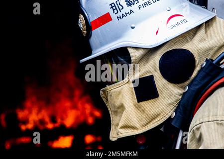 Un vigile del fuoco con il Dipartimento antincendio della città di Naha risponde a un incendio durante un esercizio bilaterale di addestramento al fuoco vivo a Camp Hansen, Okinawa, Giappone, 25 marzo 2022. Installazioni di corpi marini Pacific Fire and Emergency Services e il Dipartimento dei vigili del fuoco di Naha City hanno riunito e condotto corsi di formazione dal vivo per confrontare le diverse tecniche e metodi antincendio utilizzati da ciascun reparto per realizzare la stessa missione. Foto Stock
