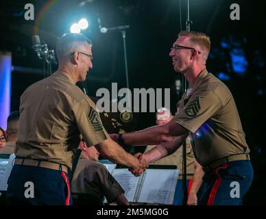 STATI UNITI Corpo Marino Maestro Gunnery Sgt. John J. Mula, partito, un bandsman con gli Stati Uniti “del presidente” Marine Corps Band, riceve un regalo dai Marines degli Stati Uniti Marine Corps Forces, Pacific (MARFORPAC) Band, durante ““una serata con i Marini”, un concerto presso l’Hale Koa Hotel, Honolulu, 25 marzo 2022. Durante l'evento, i membri della United States Marine Corps Band hanno collaborato con la MARFORPAC Band per esibirsi per i membri del servizio attivo, i veterani e i civili presenti. Foto Stock