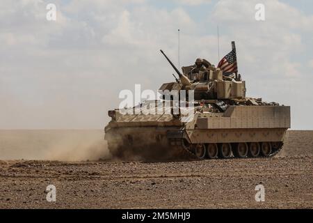 Soldati statunitensi assegnati a 2nd Platoon, Alpha Company, 1/163rd Combined Arms Battalion, azionano veicoli da combattimento Bradley M2A3 durante un'esercitazione di fuoco in Siria dal vivo il 25 marzo 2022. Gli esercizi di fuoco dal vivo offrono alle forze democratiche siriane e ai partner della Coalizione l'opportunità di simulare il realismo di combattimento in un ambiente controllato. Foto Stock