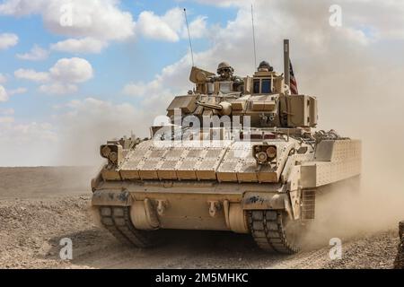 Soldati statunitensi assegnati a 2nd Platoon, Alpha Company, 1/163rd Combined Arms Battalion, azionano veicoli da combattimento Bradley M2A3 durante un'esercitazione di fuoco in Siria dal vivo il 25 marzo 2022. Gli esercizi di fuoco dal vivo offrono alle forze democratiche siriane e ai partner della Coalizione l'opportunità di simulare il realismo di combattimento in un ambiente controllato. Foto Stock