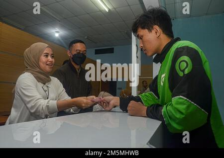 Malang, Giava Orientale, Indonesia. 29th Dec, 2022. Uno dei driver in linea ha ricevuto l'assistenza sotto forma di contanti di 600.000 Rupiah in Malang. L'assistenza è l'impatto inflazionistico dell'aumento dell'olio combustibile in Indonesia (Credit Image: © Moch Farabi Wardana/Pacific Press via ZUMA Press Wire) Foto Stock