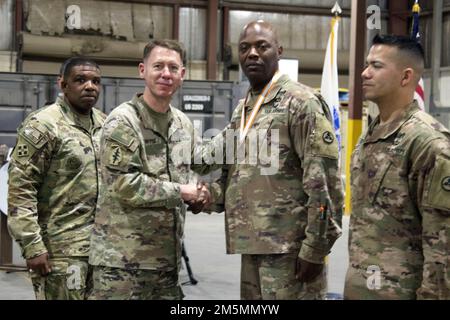 Brig. Lance G. Curtis, comandante generale, 3rd comando di supporto spedizione, scuote le mani con il Lt. Col. Jason A. Foreman durante un pranzo tattico a Camp Arifjan, Kuwait, 26 marzo 2022. Curtis ha consegnato il premio Bronze Order of Mercury a Foreman in riconoscimento dei suoi contributi negli Stati Uniti Corpo di segnale dell'esercito. Foto Stock