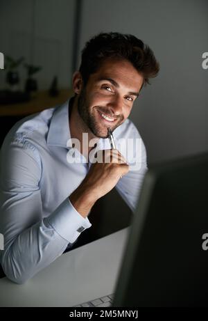 Mettere nelle ore per raggiungere il successo. un giovane uomo d'affari che lavora tardi in ufficio. Foto Stock