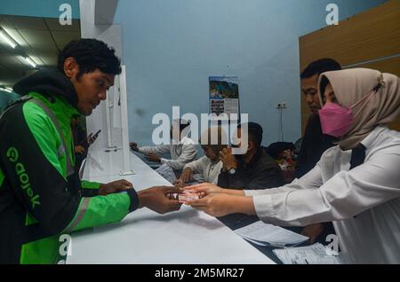 Malang, Giava Orientale, Indonesia. 29th Dec, 2022. Uno dei driver in linea ha ricevuto l'assistenza sotto forma di contanti di 600.000 Rupiah in Malang. L'assistenza è l'impatto inflazionistico dell'aumento dell'olio combustibile in Indonesia (Credit Image: © Moch Farabi Wardana/Pacific Press via ZUMA Press Wire) Foto Stock