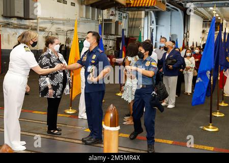 Amy Bauernschmidt, partito, comandante della portaerei di classe Nimitz USS Abraham Lincoln (CVN 72), e degli Stati Uniti 2022 27 Ambasciata nelle Filippine Chargé d’Affaires, ad interim, Heather Variava saluta i leader militari e civili delle Filippine quando arrivano nella baia di Hangar a bordo di Abraham Lincoln. Mentre nelle Filippine, Abraham Lincoln ha celebrato il 70th° anno degli Stati Uniti Alleanza filippina attraverso attriti di visitatori distinti in mare, tour in nave, progetti di relazioni con la comunità, tour MWR e un ricevimento ospitato nell'hangar della nave Foto Stock