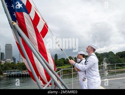 SYDNEY (27 marzo 2022) – riparatore di macchinari 2nd Classe David Livesay, di Lexington, North Carolina e tecnico addetto alla manutenzione Hull, Fireman Carson Daub, di Simi Valley, California, entrambi assegnati all'asta sottomarina di Emory S. Land-class USS Frank Cable (COME 40), Alzate il National Ensign mentre la nave ormeggio sul molo di Sydney per una visita al porto programmata, il 27 marzo. Frank Cable è attualmente in pattuglia che conduce la manutenzione e la logistica di spedizione a sostegno della sicurezza nazionale nel settore delle operazioni della flotta degli Stati Uniti 7th. Foto Stock