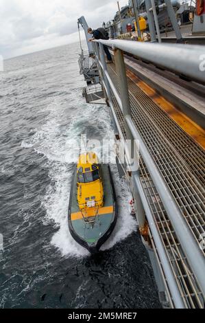 SYDNEY (27 marzo 2022) – Una nave pilota con sede a Sydney si avvicina alla gara sottomarina USS Frank Cable (AS 40) di Emory S. Land per portare a bordo i piloti del porto mentre la nave transita a Sydney per una visita al porto programmata, il 27 marzo. Frank Cable è attualmente in pattuglia che conduce la manutenzione e la logistica di spedizione a sostegno della sicurezza nazionale nel settore delle operazioni della flotta degli Stati Uniti 7th. Foto Stock