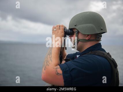 SYDNEY (27 marzo 2022) – Master-at-Arms 2nd Class James Phelps di Indianapolis, Indiana, assegnato alla gara sottomarina di Emory S. Land-class USS Frank Cable (COME 40), è in piedi un orologio di protezione della forza mentre la nave transita a Sydney, 27 marzo. Frank Cable è attualmente in pattuglia che conduce la manutenzione e la logistica di spedizione a sostegno della sicurezza nazionale nel settore delle operazioni della flotta degli Stati Uniti 7th. Foto Stock