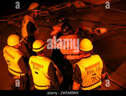 OCEANO ATLANTICO (26 marzo 2022) – i marinai collegano un cavo elettrico prima di condurre i depositi a carico durante un rifornimento in mare con la nave da carico secca di classe Lewis e Clark USNS William McLean (T AKE-12) a bordo del cacciatorpediniere missilistico guidato di classe Arleigh Burke USS Porter (DDG 78), marzo 26. Porter, schierato in futuro a Rota, Spagna, sta attualmente partecipando all'esercizio della Task Force nell'area operativa della flotta degli Stati Uniti 2nd. TFEX funge da esercizio di certificazione per l'implementazione indipendente di navi ed è progettato per testare la preparazione e le prestazioni della missione in operazioni integrate. Foto Stock