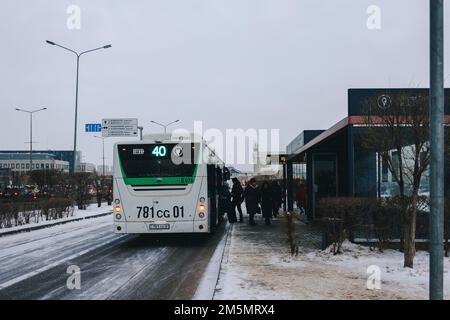 Astana, Kazakistan - 23 novembre 2022: Persone in attesa di trasporto pubblico. Fermate dell'autobus riscaldate con aria condizionata. Caldo d'inverno, fresco d'estate. Foto Stock